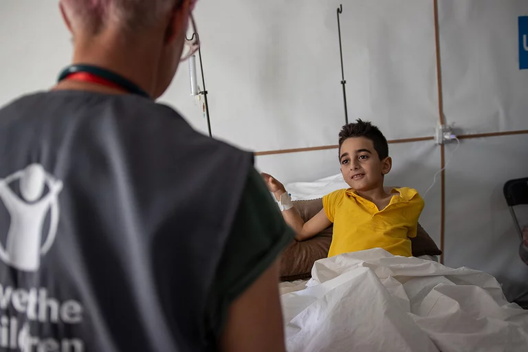 De tienjarige Ahmed wordt geholpen door verpleegkundige Becky De tienjarige Ahmed wordt geholpen door verpleegkundige Becky