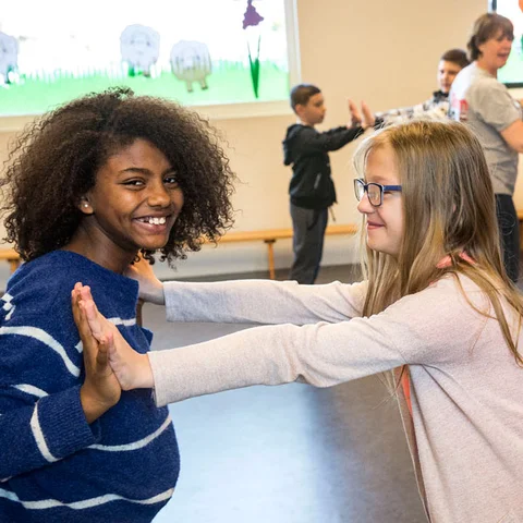kinderen spelen een spel door tegen elkaars handen te duwen