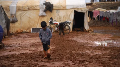 CH1793340-A-child-playing-and-walking-through-flood-water-and-mud-in-a-camp-for-internally-displaced-people-in-Idlib-Syria.JPG