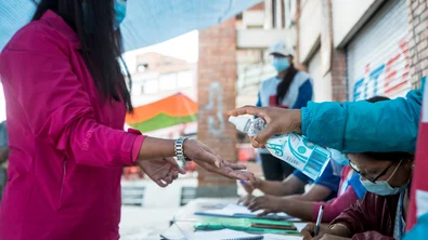 CH1553547-Woman-sanitises-hands-at-vaccination-centre-Nepal.jpg