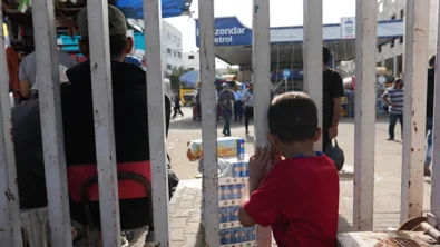 CH1909307-A-child-standing-behind-a-fence-in-Gaza