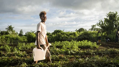 Junior, 16, watering plants in a community garden in Malaita Province, the Solomon Islands