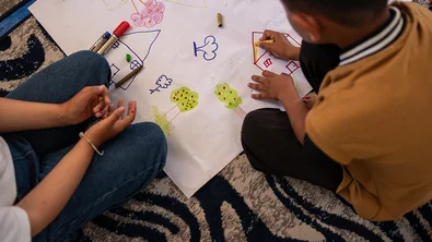 Shadi en zijn nicht Aya tekenen in een leerplek van Save the Children