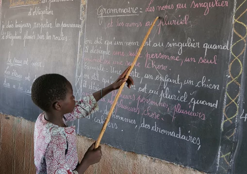CH1545245-Souleymane-aged-14-points-to-words-on-a-blackboard-at-school-Yatenga-province-Burkina-Faso