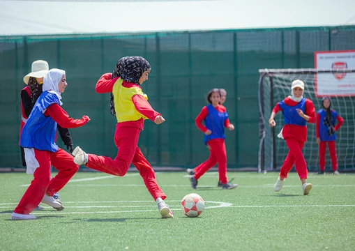 Meiden voetballen in een vluchtelingenkamp in Jordanië