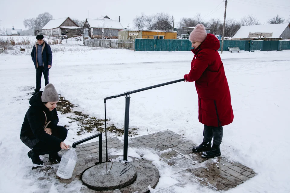 CH1752245-Village-head-Iryna-and-Save-the-Children-staff-member-collect-water-at-manual-water-pump-constructed-by-Save-the-Children