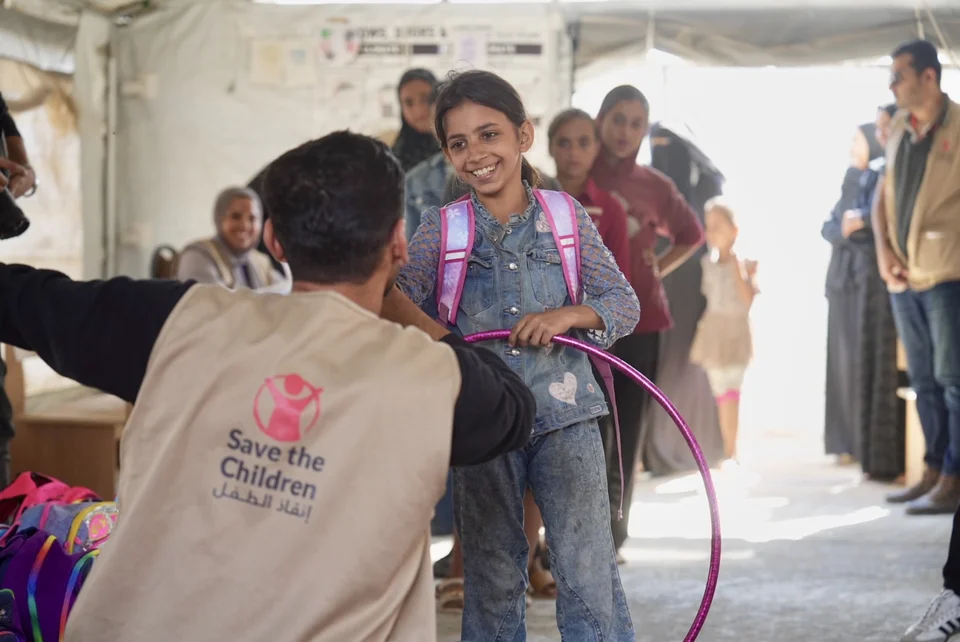 kinderen krijgen schooltassen van Save the Children