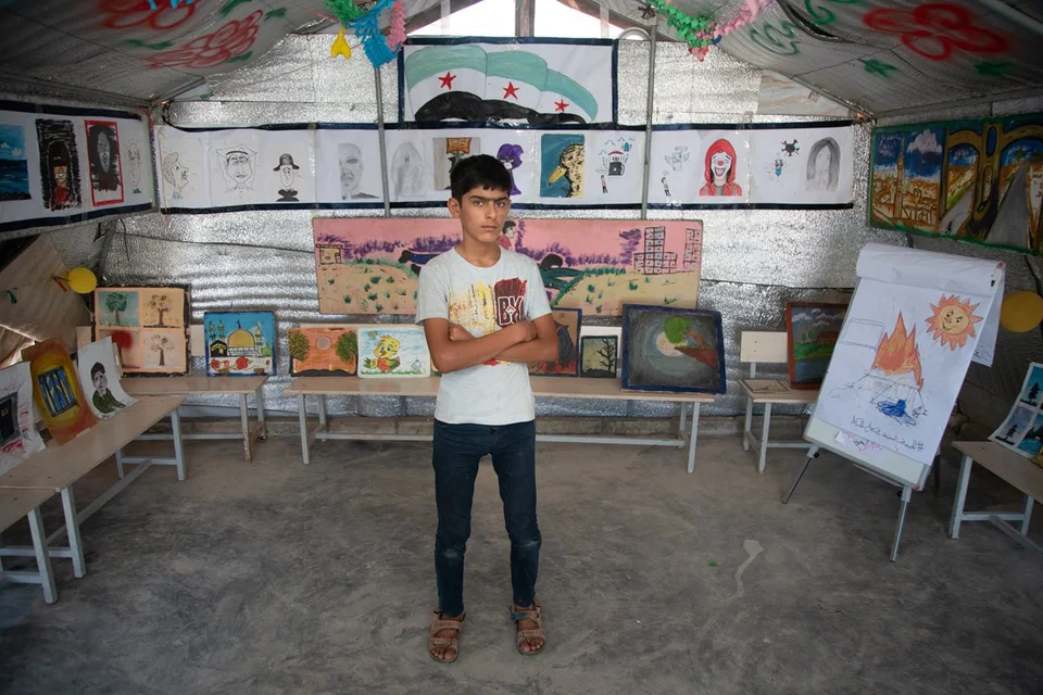 CH1572713-Omar-now-14-with-his-art-work-at-an-exhibition-in-the-camp-where-he-lives-Syria.aspx%3Fwidth%3D1200%26height%3D800%26ext%3D.jpg.webp