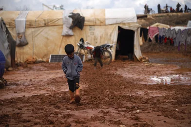 CH1793340-A-child-playing-and-walking-through-flood-water-and-mud-in-a-camp-for-internally-displaced-people-in-Idlib-Syria.JPG