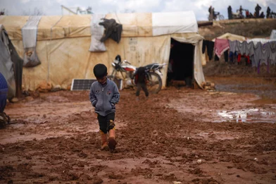 CH1793340-A-child-playing-and-walking-through-flood-water-and-mud-in-a-camp-for-internally-displaced-people-in-Idlib-Syria.JPG