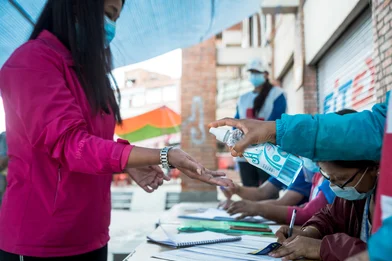 CH1553547-Woman-sanitises-hands-at-vaccination-centre-Nepal.jpg