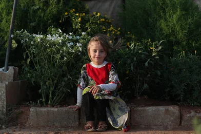 CH1731800-Abeer-6-sitting-in-front-of-her-family-s-small-garden-that-s-next-to-their-tent-at-the-displacement-camp-where-they-re-living-in-Syria.JPG