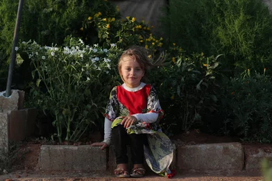 CH1731800-Abeer-6-sitting-in-front-of-her-family-s-small-garden-that-s-next-to-their-tent-at-the-displacement-camp-where-they-re-living-in-Syria.JPG