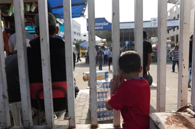 CH1909307-A-child-standing-behind-a-fence-in-Gaza