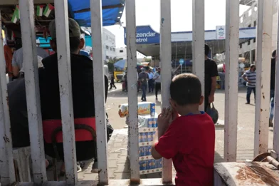 CH1909307-A-child-standing-behind-a-fence-in-Gaza