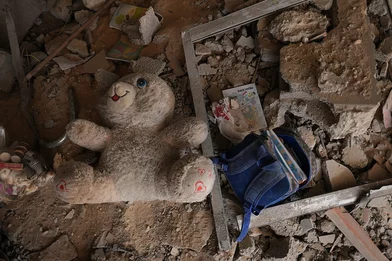 CH1909346-A-child-s-school-backpack-and-a-doll-among-a-rubble-in-Gaza-LR