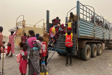 save_the_children_staff_assisting_women_and_children_board_truck
