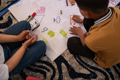 Shadi en zijn nicht Aya tekenen in een leerplek van Save the Children