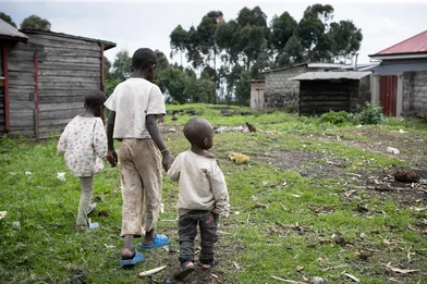 Drie broers lopen in het vluchtelingenkamp aan de rand van Goma in DRC Drie broers lopen in het vluchtelingenkamp aan de rand van Goma in DRC