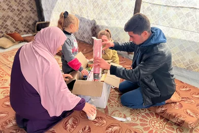 Een familie ontvangt een voedselpakket in Gaza Een familie ontvangt een voedselpakket in Gaza