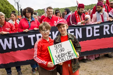 Rode Lijn protest: twee jongens met een bord met de tekst 'geen kind verdient oorlog'