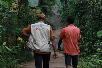 Medewerker van Save the Children wandelt met een man