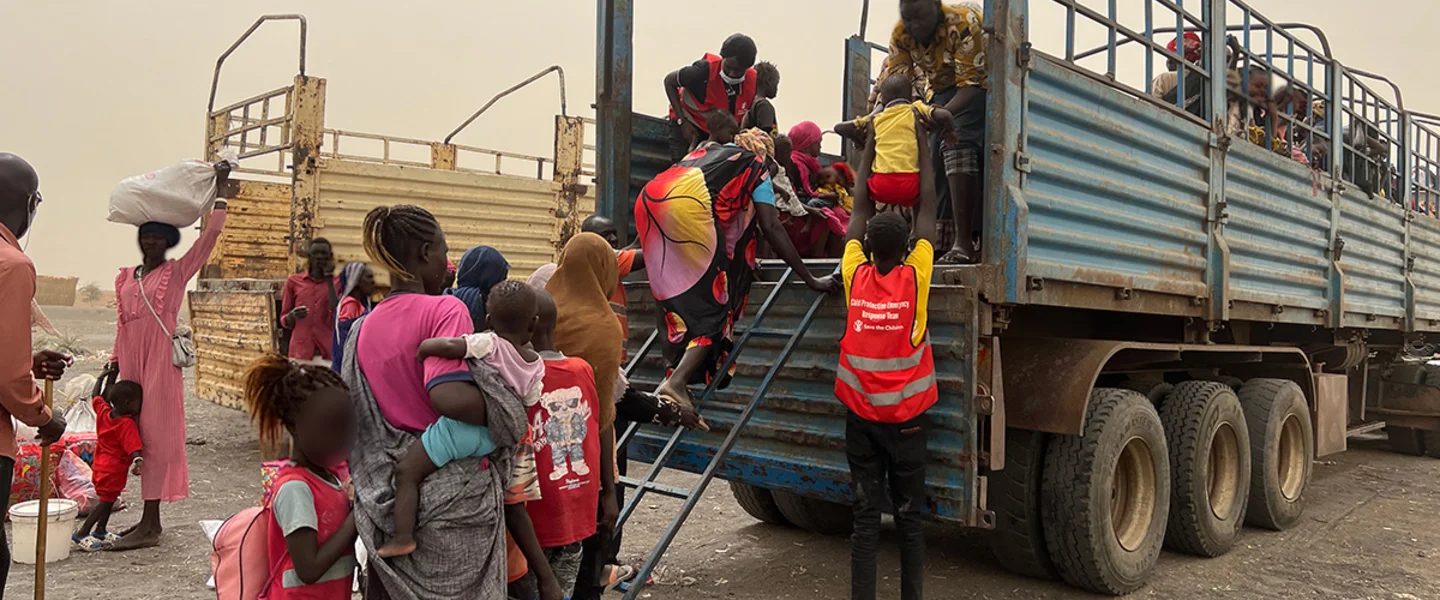 save_the_children_staff_assisting_women_and_children_board_truck
