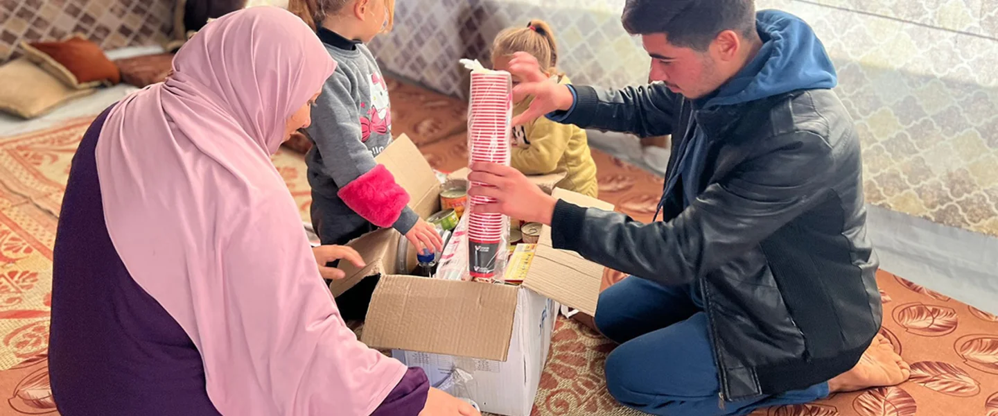 Een familie ontvangt een voedselpakket in Gaza
