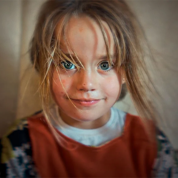 Portret van een meisje, ze kijkt direct en vrolijk in de camera