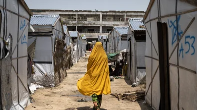 CH1727450-Miriam-16-walks-past-tents-in-a-camp-for-internally-displaced-people-in-Borno-Nigeria.jpg