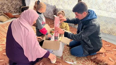 Een familie ontvangt een voedselpakket in Gaza