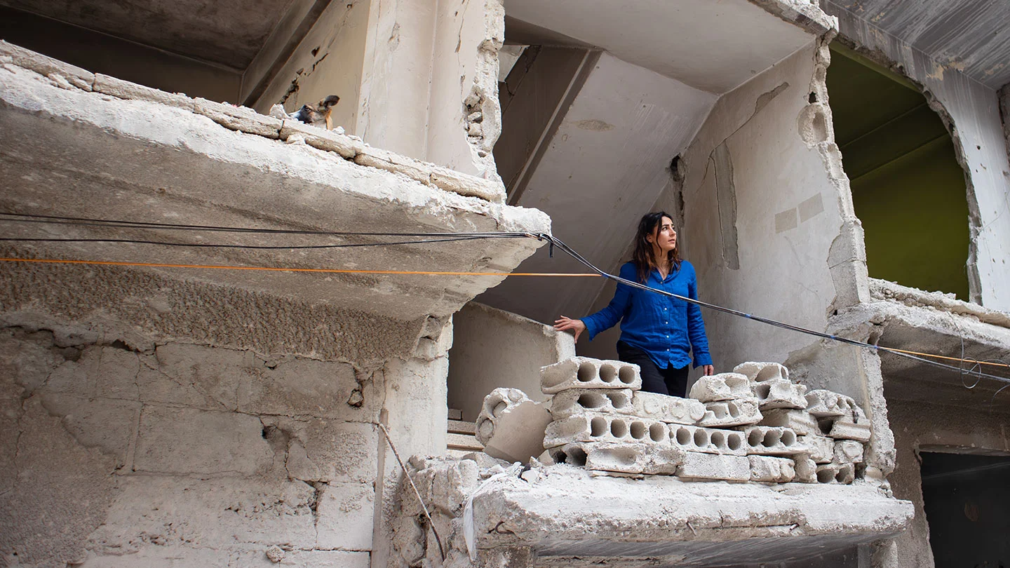 Nadia Moussaid staat in het trappenhuis van een verwoest gebouw, Syrië