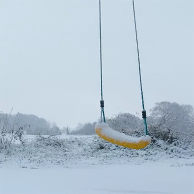 gele schommel in de sneeuw