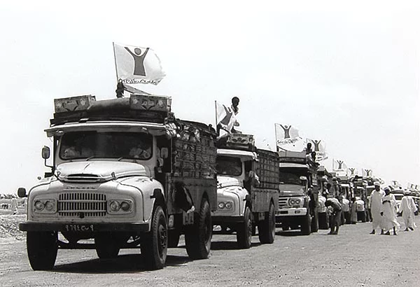 een kolonne van trucks met wapperende vlaggen van Save The Children rijden over een weg een kolonne van trucks met wapperende vlaggen van Save The Children rijden over een weg