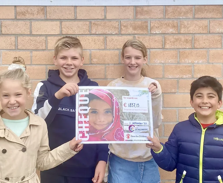 4 kinderen houden een cheque vast