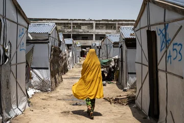 CH1727450-Miriam-16-walks-past-tents-in-a-camp-for-internally-displaced-people-in-Borno-Nigeria.jpg