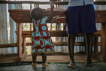 CH1542620-Mary-16-plays-with-her-daughter-at-school-in-a-refugee-settlement-in-West-Nile-Uganda