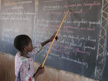 CH1545245-Souleymane-aged-14-points-to-words-on-a-blackboard-at-school-Yatenga-province-Burkina-Faso