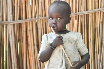 CH1607034-Adut-15-standing-outside-holding-a-stick_1