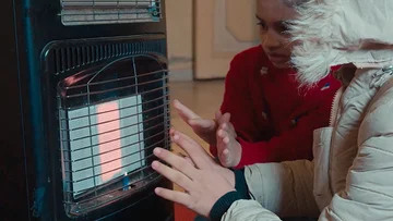 Kinderen warmen hun handen bij electrisch kacheltje